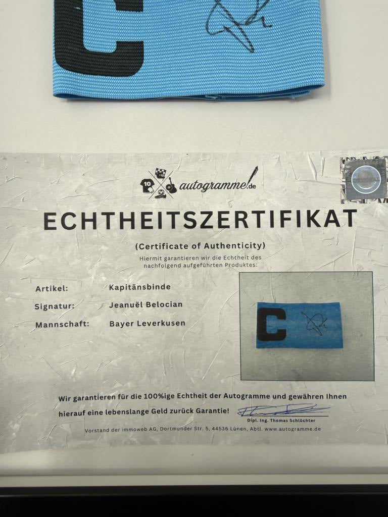 Kapitänsbinde Jeanuël Belocian signiert im Rahmen Bayer Leverkusen Autogramm