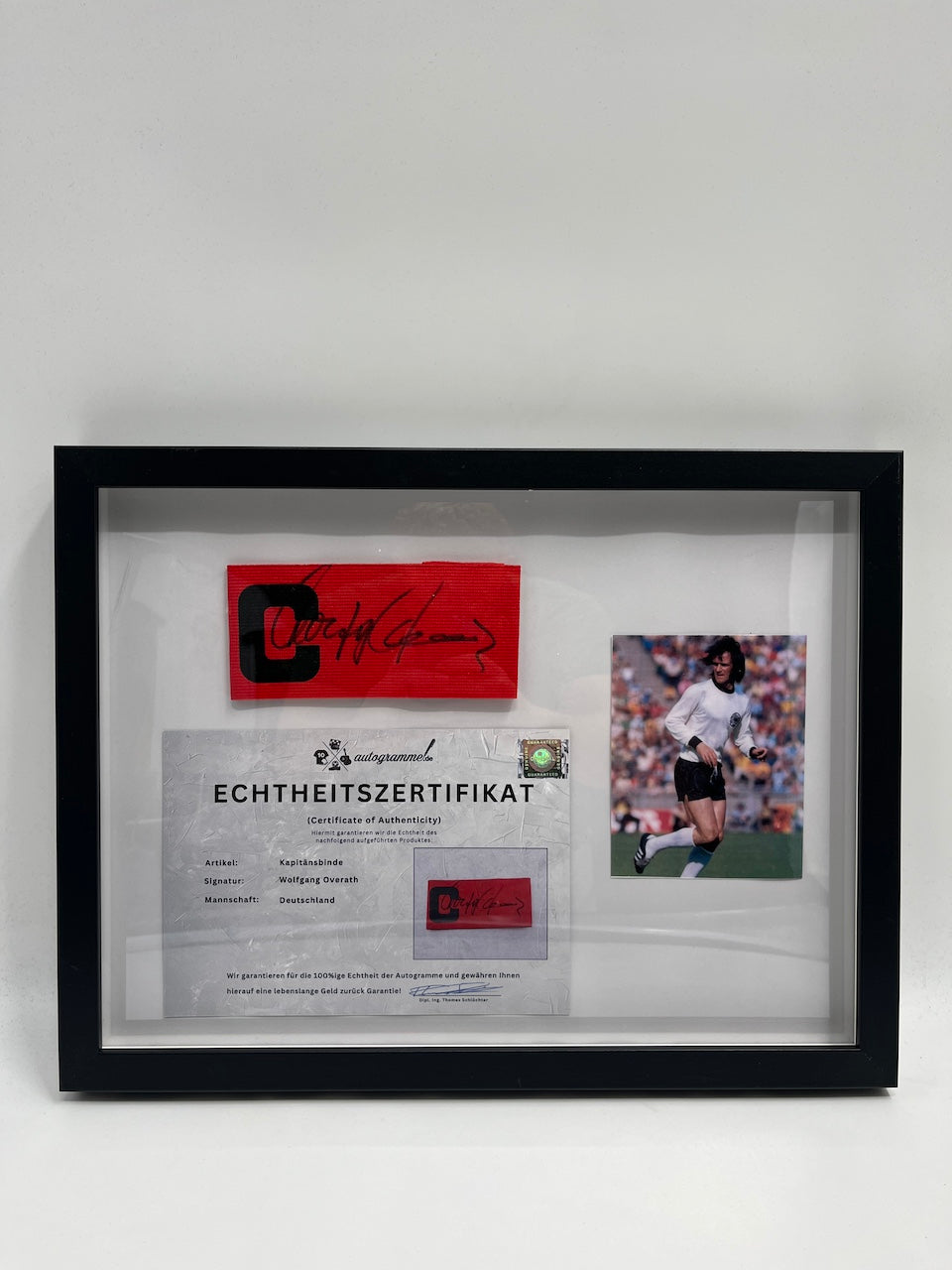 Captain's armband signed by Wolfgang Overath in a DFB football autograph COA frame