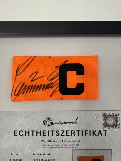 Kapitänsbinde Toni Schumacher signiert im Rahmen FC Köln Fußball Autogramm