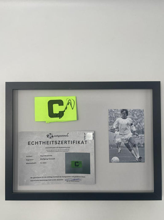 Kapitänsbinde Wolfgang Overath signiert im Rahmen 1. FC Köln Autogramm