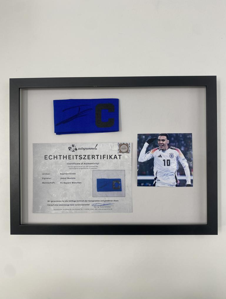 Captain's armband signed by Jamal Musiala in a Bayern Munich autograph frame