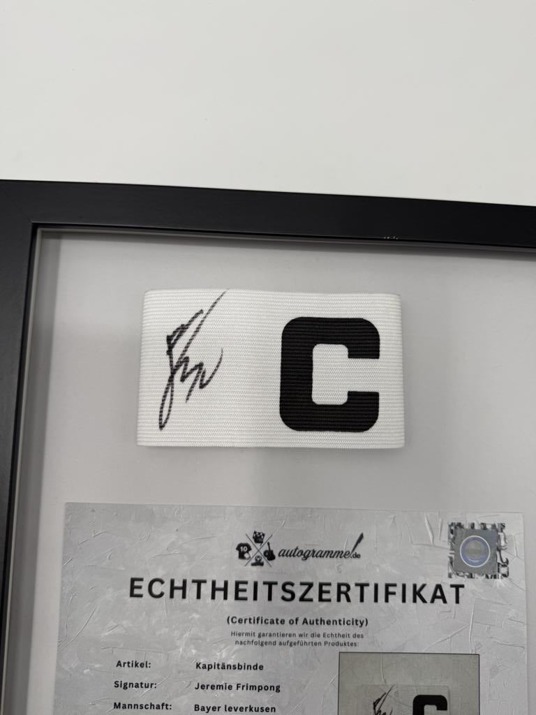 Captain's armband signed by Jeremie Frimpong in a frame, Bayer 04 Leverkusen autograph
