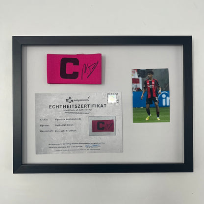 Kapitänsbinde Nathaniel Brown signiert im Rahmen Eintracht Frankfurt pink