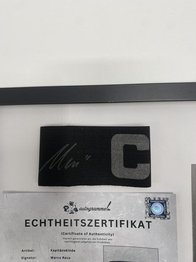 Brazalete de capitán firmado por Marco Reus en un marco con certificado de autenticidad del Borussia Dortmund.