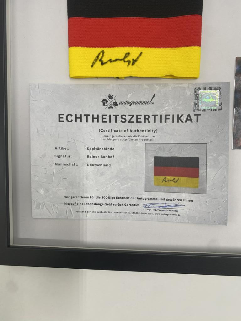 Brazalete de capitán firmado por Rainer Bonhof, enmarcado y con certificado de autenticidad de Alemania.