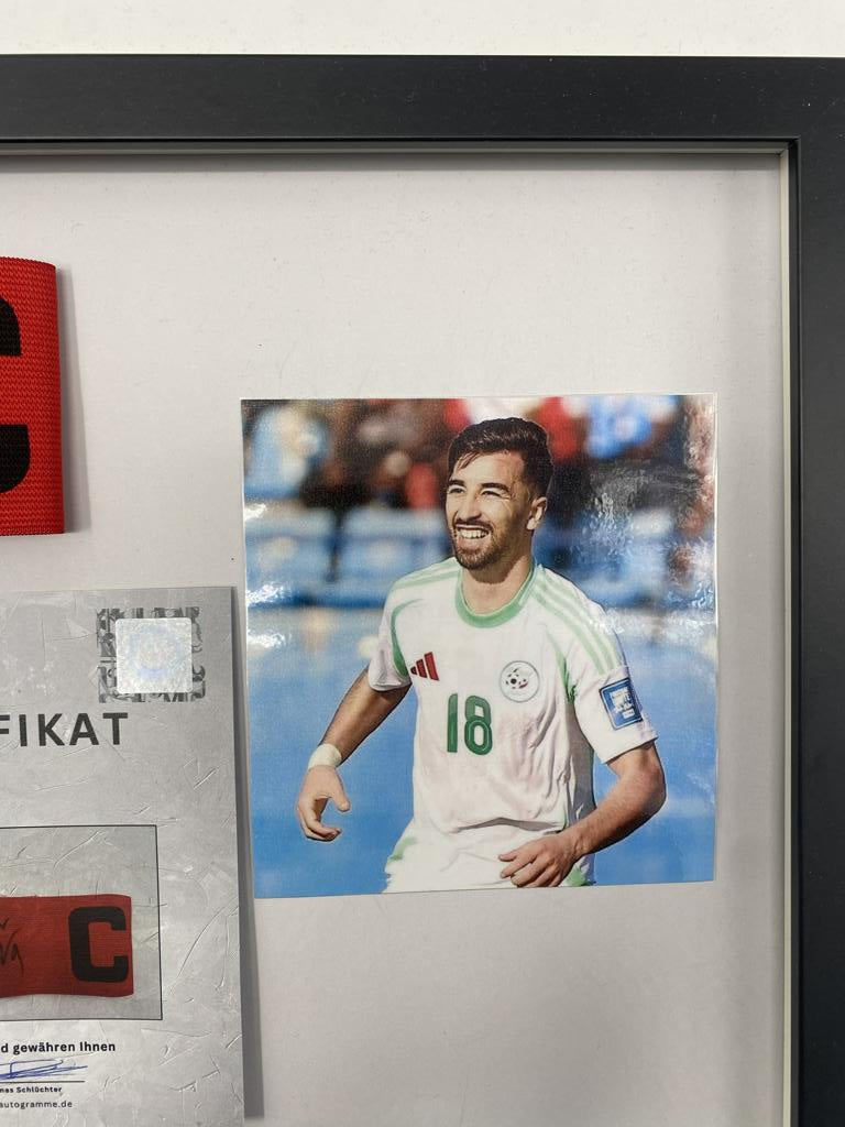 Brazalete de capitán firmado por Mohamed Amoura enmarcado, Argelia. Certificado de Autenticidad de Autógrafos.