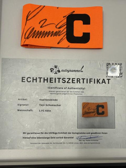 Kapitänsbinde Toni Schumacher signiert im Rahmen FC Köln Fußball Autogramm