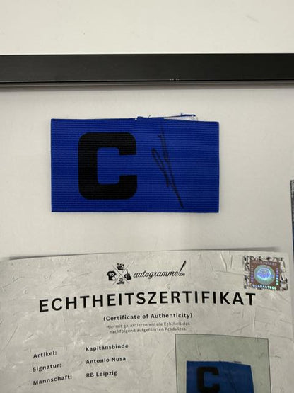 Kapitänsbinde Antonio Nusa signiert im Rahmen RB Leipzig Autogramm