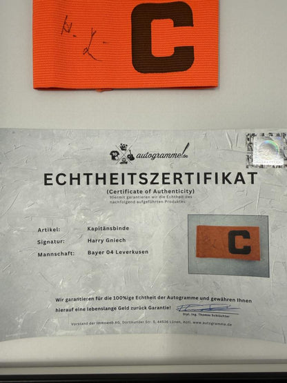 Kapitänsbinde Harry Gniech signiert im Rahmen Bayer Leverkusen Autogramm