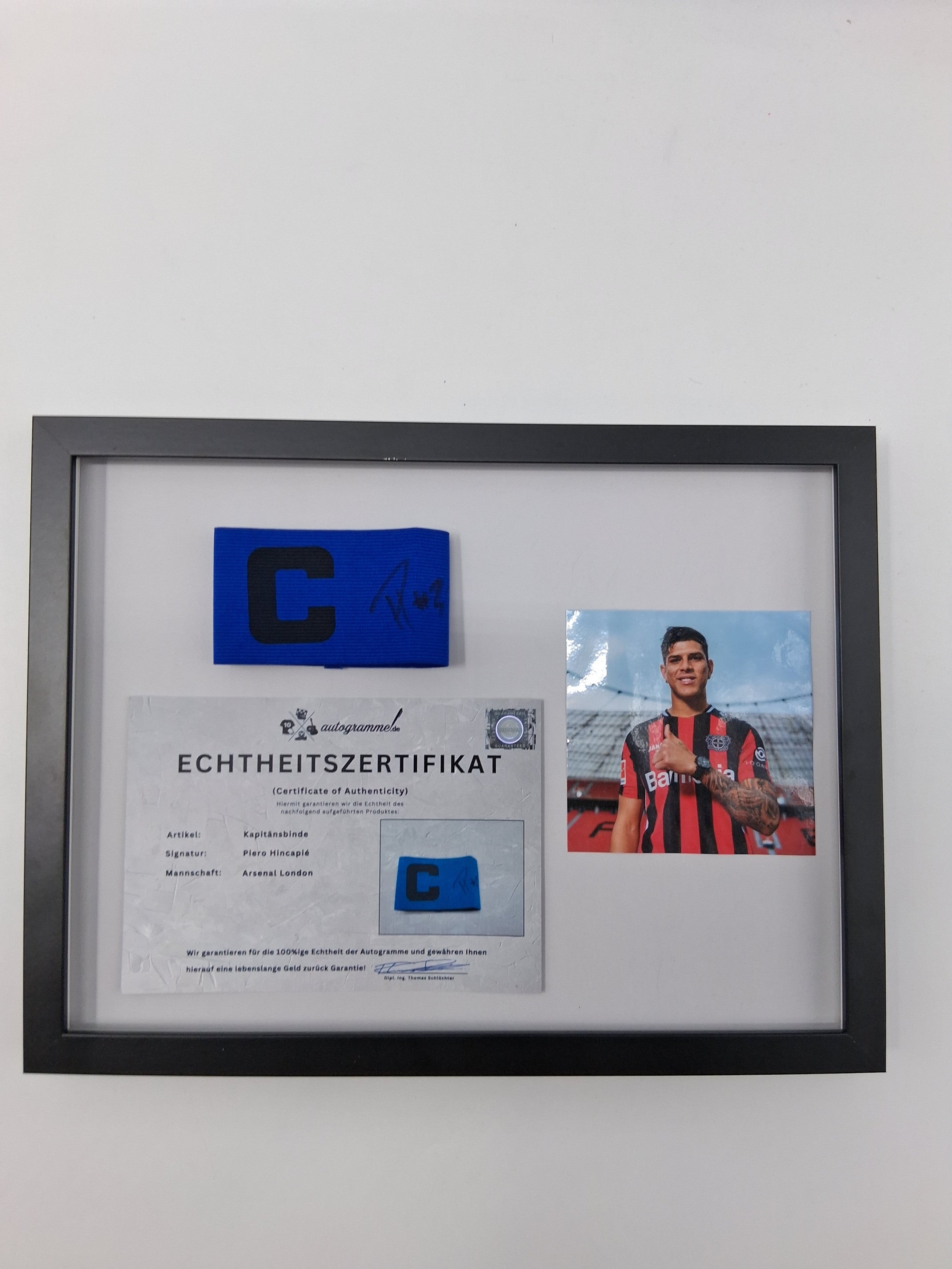 Captain's armband signed by Piero Hincapié in a frame, autographed by Bayer 04 Leverkusen