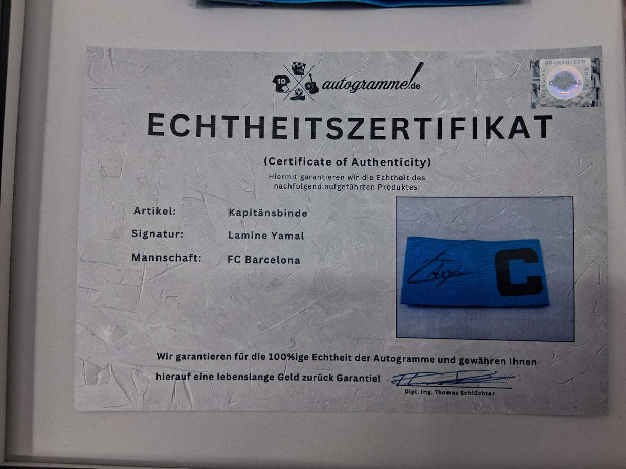 Captain's armband signed by Lamine Yamal in a framed FC Barcelona COA autograph