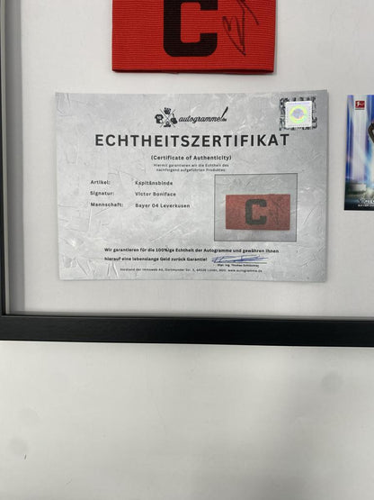 Kapitänsbinde Victor Boniface signiert im Rahmen Bayer Leverkusen Autogramm COA